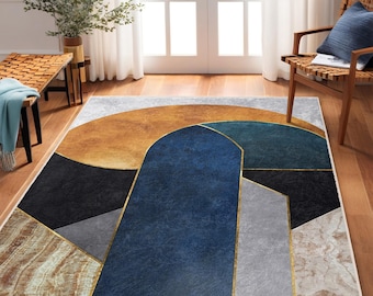 May include: Abstract geometric rug with a blue, teal, gold, and gray design. The rug has a white border and is on a wooden floor.