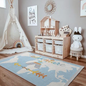 May include: A blue and white rug with a world map design and the word "adventure" written across it. The rug features a yellow arrow with a brown and white teepee design.