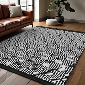 May include: Black and white geometric area rug with a repeating pattern of squares and lines. The rug has a black border.