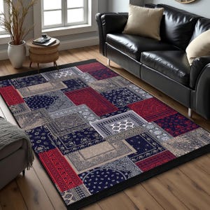 May include: A multi-colored patchwork rug with a black border. The rug features a variety of geometric patterns in shades of red, blue, and gray.