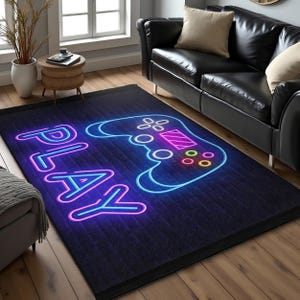 Puede incluir: Una alfombra azul oscuro con un patrón de ladrillo, en la que se representa un letrero de neón azul y morado con la palabra "PLAY" y un mando de videojuego.