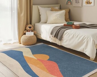 May include: A rectangular area rug with an abstract design in shades of blue, orange, and beige. The rug features a textured appearance and is placed on a wooden floor in a bedroom setting. The rug's design includes curved lines and shapes.