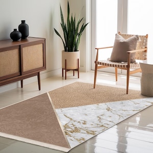 May include: A beige, brown, and white geometric area rug with a marble pattern. The rug is in a living room setting with a chair and a side table.