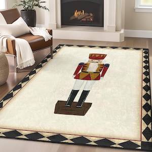 Puede incluir: Una alfombra con estampado blanco y negro con una ilustración de cascanueces rojo, dorado y azul en el centro. El cascanueces está de pie sobre una base de madera.