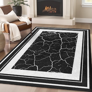 May include: Black and white area rug with a cracked marble design and a thick black and white border.