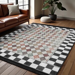 May include: A black and white checkered rug with a diamond pattern in the center. The diamond pattern is in shades of brown, green, and pink.