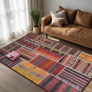 Può includere: Un tappeto patchwork colorato con una varietà di motivi geometrici in tonalità di rosso, arancione, giallo, blu e marrone. Il tappeto è steso su un pavimento in legno in un soggiorno con un divano marrone sullo sfondo.