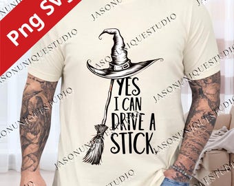 Könnte beinhalten: Ein cremefarbenes Kurzarm-T-Shirt mit einer schwarzen Grafik eines Hexenhutes, der auf einem Besenstiel sitzt. Der Text "YES I CAN DRIVE A STICK" ist in einer fetten, stilisierten schwarzen Schrift rechts neben dem Besen abgebildet.