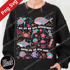 May include: Black sweatshirt featuring colorful sea creatures like a whale, shark, and jellyfish. The design includes the text "all of us are different, none of us are less". The sea creatures are decorated with floral patterns.