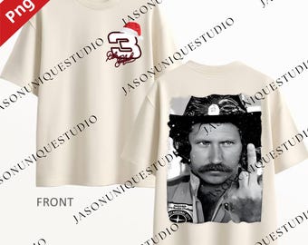 May include: Cream-colored t-shirt featuring a front design with the number 3 in red and a Santa hat, along with a signature. The back of the shirt displays a black and white image of a man with a mustache and a gesture.