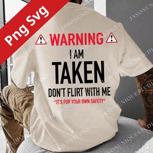 Może przedstawiać: Kremowa koszulka z napisem "WARNING I AM TAKEN DON'T FLIRT WITH ME *IT'S FOR YOUR OWN SAFETY*" w kolorze czarnym i czerwonym. Koszulka ma symbol ostrzegawczy nad słowem "WARNING".