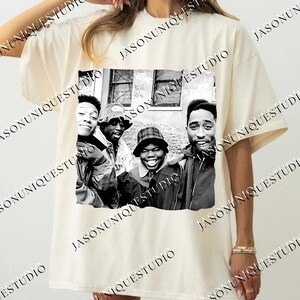 a woman wearing a t - shirt with a picture of a group of people on