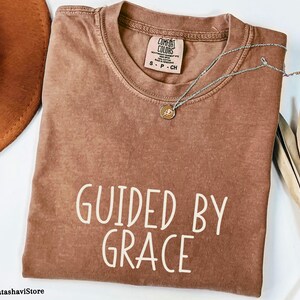 恵みに導かれて インスピレーションあふれるクリスチャンTシャツ - スピリチュアルな信者のためのユニセックス信仰服