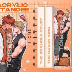 Puede incluir: Soporte acrílico con dos figuras masculinas, una pelirroja con chaqueta naranja, otra rubia con top negro. El soporte mide 18 cm de alto y contiene texto: "ACRYLIC STANDEE", "THE FOXHOLE COURT", "THE RAVEN KING", y "THE KING'S MEN".