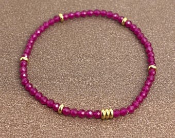 Op de afbeelding: Een armband van roze edelstenen met gouden accenten. De armband is gemaakt van kleine, gefacetteerde kralen en heeft een delicate, vrouwelijke uitstraling.