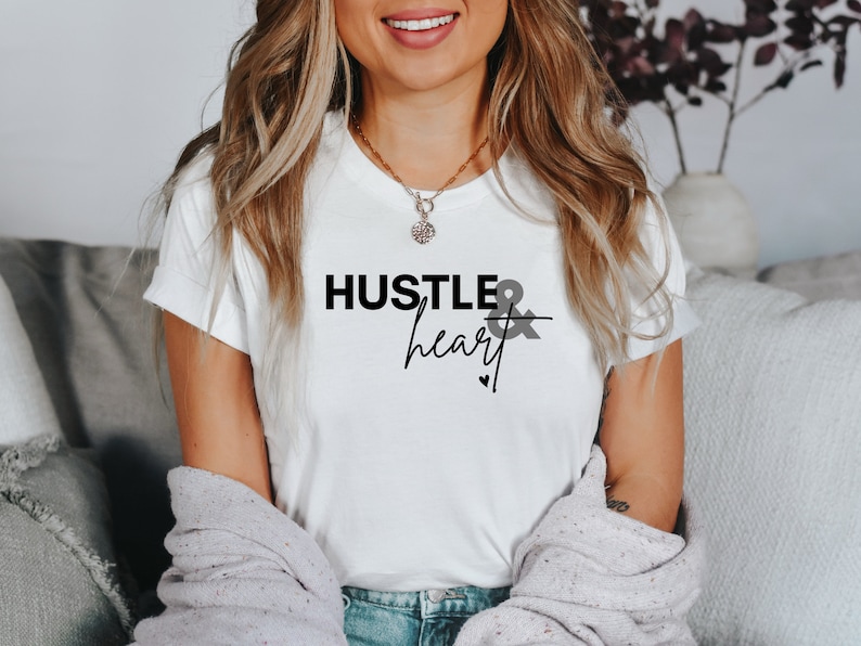 May include: White t-shirt with the text "Hustle & heart" in black lettering.