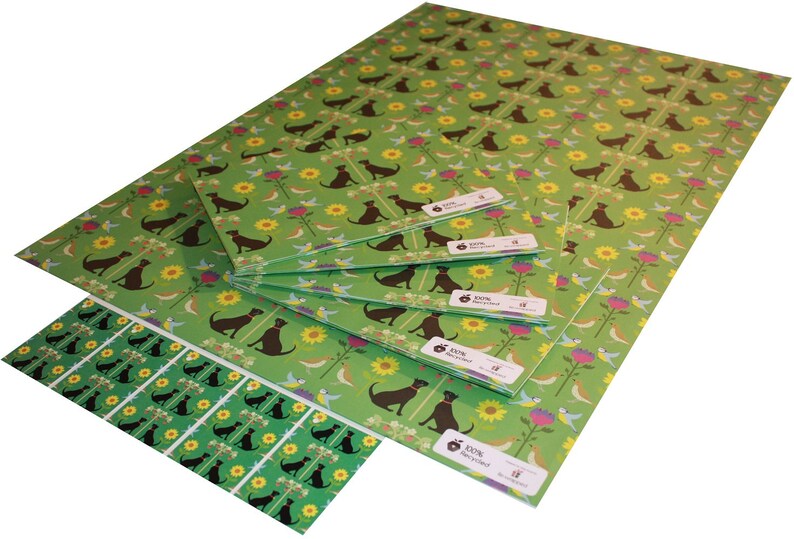 May include: Sheets of green wrapping paper with a repeating pattern of brown dogs, yellow sunflowers, pink flowers, and blue birds. The paper is labeled "100% Recycled".