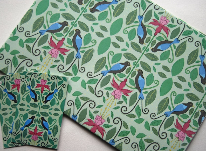 Puede incluir: Papel de regalo verde con un patr&oacute;n repetido de p&aacute;jaros azules con colas largas, flores rosas y hojas verdes.