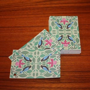 Puede incluir: Un juego de seis tarjetas con un patr&oacute;n repetitivo de p&aacute;jaros azules, flores rosas y hojas verdes. Las tarjetas est&aacute;n impresas sobre un fondo blanco.