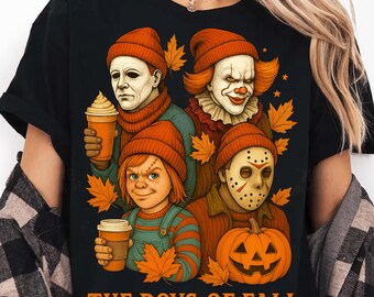 May include: Black t-shirt featuring a graphic of four horror movie characters wearing orange beanies and holding coffee cups, surrounded by autumn leaves and a jack-o'-lantern. The text "THE BOYS OF FALL" is printed at the bottom.