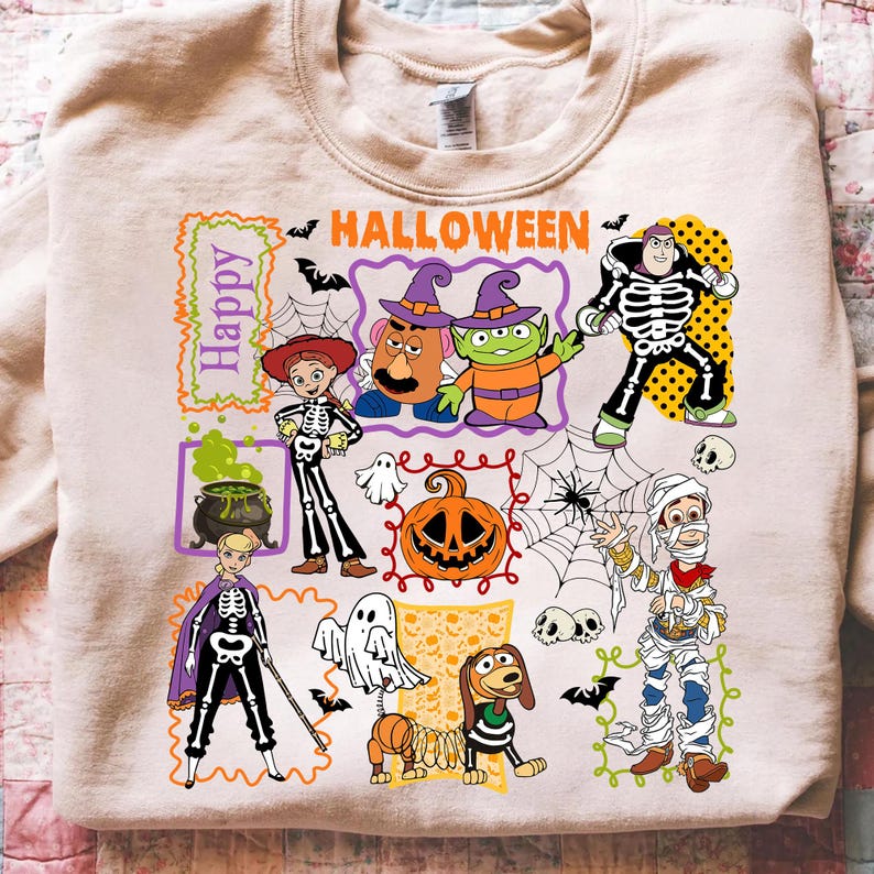 May include: Beige Halloween-themed sweatshirt with cartoon characters in costumes. The design includes a pumpkin, ghosts, and the words "Happy Halloween". The sweatshirt is made of a soft material.