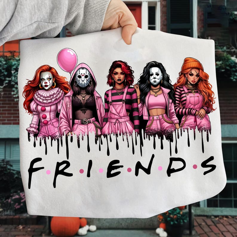 May include: White graphic tee featuring five stylized horror characters in pink outfits, with a pink balloon. The word "FRIENDS" is written in black with pink dots. Black drips are at the top of the word.