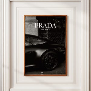 Old money fashion style black-and-white Porsche artwork with Prada-inspired text, creating a moody luxury aesthetic. This elegant print is ideal for old money prints, old money aesthetic décor, and upscale fashion poster displays. Perfect for lovers of luxury prints, luxury car poster décor, and designer interiors seeking prada fashion inspired poster styling and dark elegance minimalist fashion home decor accents.