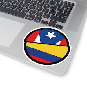 Puede incluir: Una pegatina redonda con un diseño rojo, blanco, azul y amarillo. La pegatina presenta una versión estilizada de las banderas de Puerto Rico y Colombia.