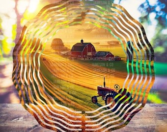 May include: A metal wind spinner with a circular design featuring a sunset scene of a red barn, a farmhouse, and a tractor in a field of golden wheat. The spinner has multiple layers of wavy lines in silver and green.