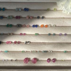 a white flower sitting next to a row of earrings
