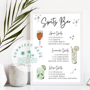 Peut inclure: Une affiche encadr&eacute;e avec le texte "Spritz Bar" et des recettes de cocktails. Les recettes incluent Aperol Spritz, Limoncello Spritz et Hugo Spritz. L'affiche est d&eacute;cor&eacute;e d'illustrations des cocktails et de leurs garnitures.