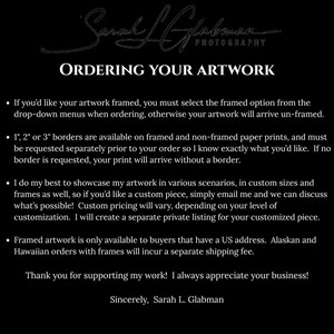 The image is a black and white photograph of a sign with text and a signature.