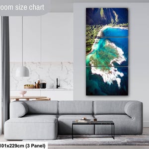 Aerial photograph of Kauai Hawaii coastline near Na Pali Coast showing turquoise ocean reef, shore break waves, and lush green mountains at sunset. Captured from helicopter, detailed ocean floor visible with vibrant tropical water and beach shoreline.