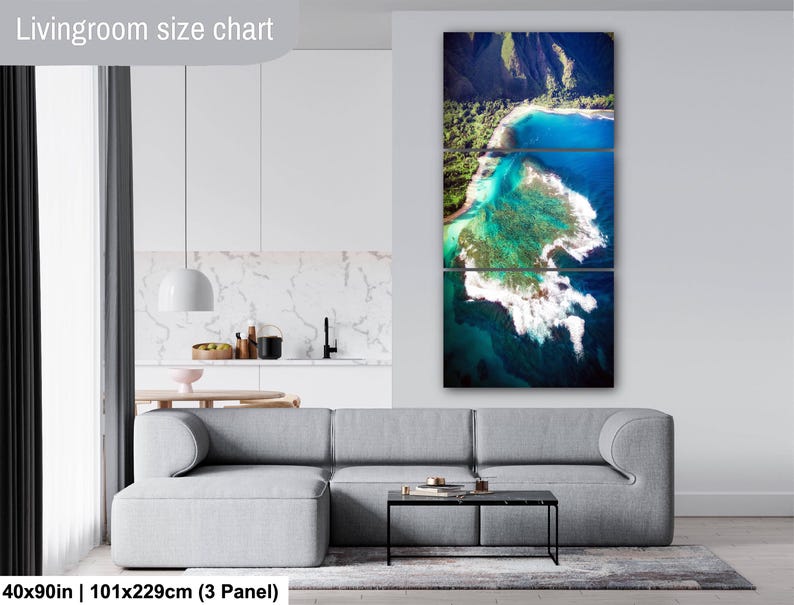Aerial photograph of Kauai Hawaii coastline near Na Pali Coast showing turquoise ocean reef, shore break waves, and lush green mountains at sunset. Captured from helicopter, detailed ocean floor visible with vibrant tropical water and beach shoreline.