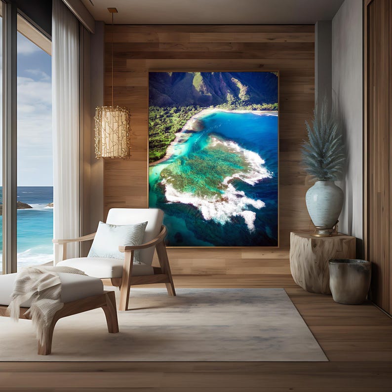 Aerial photograph of Kauai Hawaii coastline near Na Pali Coast showing turquoise ocean reef, shore break waves, and lush green mountains at sunset. Captured from helicopter, detailed ocean floor visible with vibrant tropical water and beach shoreline.