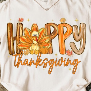 Könnte beinhalten: Weißes T-Shirt mit Thanksgiving-Motiv. Das Shirt zeigt die Worte "HAPPY Thanksgiving" in orangefarbenen und braunen Buchstaben. In der Mitte befindet sich ein Cartoon-Truthahn mit orangefarbenen und gelben Federn, zusammen mit einem kleinen Kürbis und Herbstblättern.