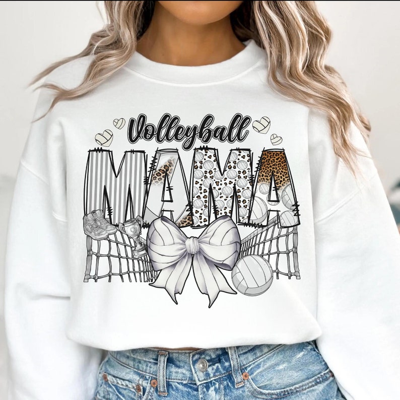 a woman wearing a white sweatshirt that says volleyball mama