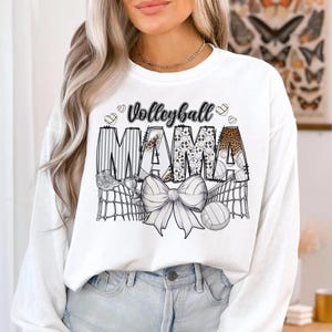 a woman wearing a white volleyball mama sweatshirt