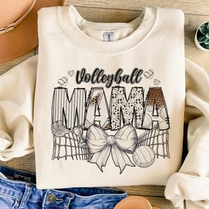 a t - shirt that says volleyball mama with a bow
