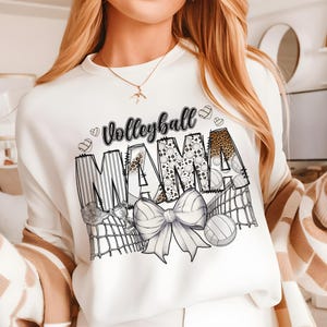a woman wearing a white sweatshirt with the word mama printed on it