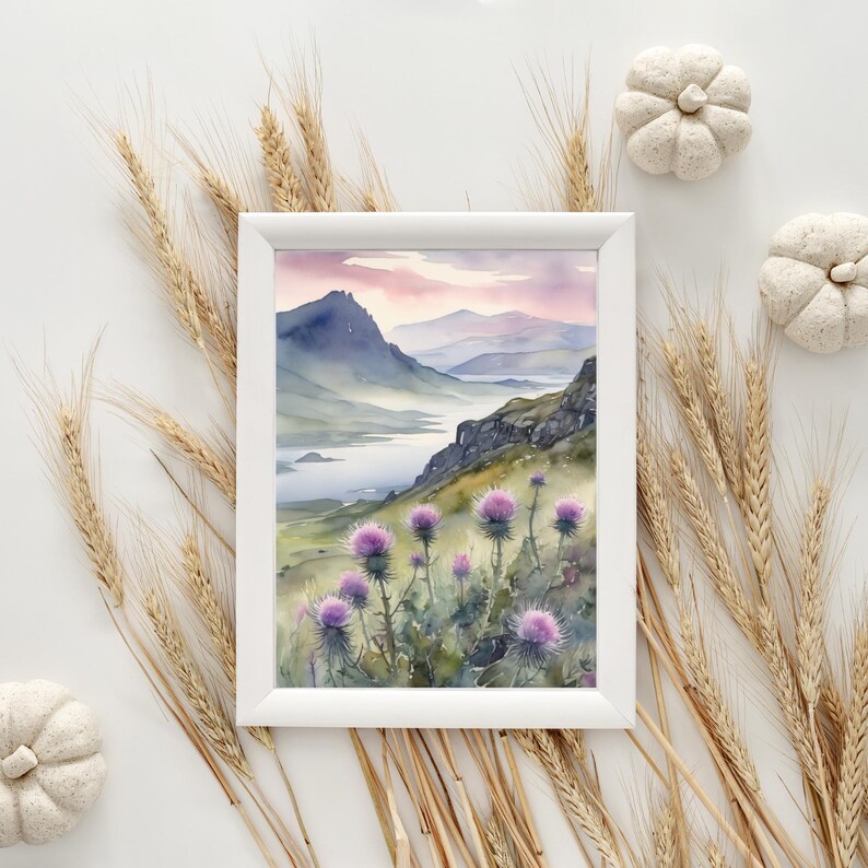 以下が含まれることがあります： 湖を前景に描いた山岳風景の水彩画。絵は白い額縁に収められており、前景に紫色の花が描かれている。