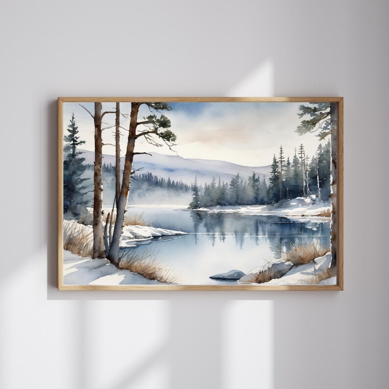 May include: A watercolor painting of a snowy winter scene with a lake and trees. The lake is calm and reflects the sky and trees. The trees are mostly evergreens and are covered in snow. The sky is a light blue with some clouds.