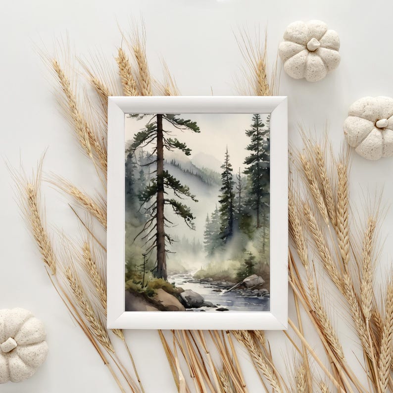 May include: A watercolor painting of a misty forest scene with a river flowing through it. The painting is framed in a white frame and is surrounded by wheat stalks.