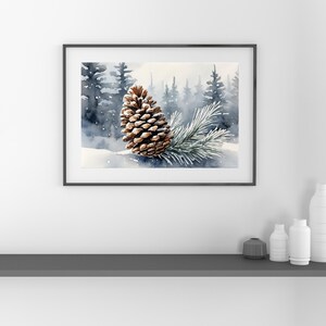 May include: Watercolor painting of a pine cone and a pine branch on a snowy surface, set against a backdrop of a misty forest. The artwork is framed in a black frame, evoking a serene winter scene.