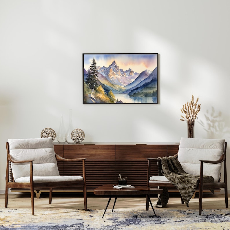 May include: Watercolor painting of a mountain range with a lake in the foreground. The mountains are a light blue and purple color, and the lake is a dark blue. There are trees on the left side of the painting, and the sky is a light pink and orange color.