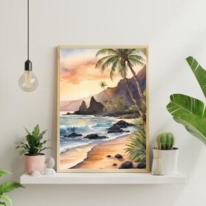May include: Watercolour print depicting a tropical beach scene with palm trees, mountains, and ocean waves. The artwork features a warm colour palette of orange, yellow, and blue, framed in a light wood frame. The beach has golden sand and dark rocks.