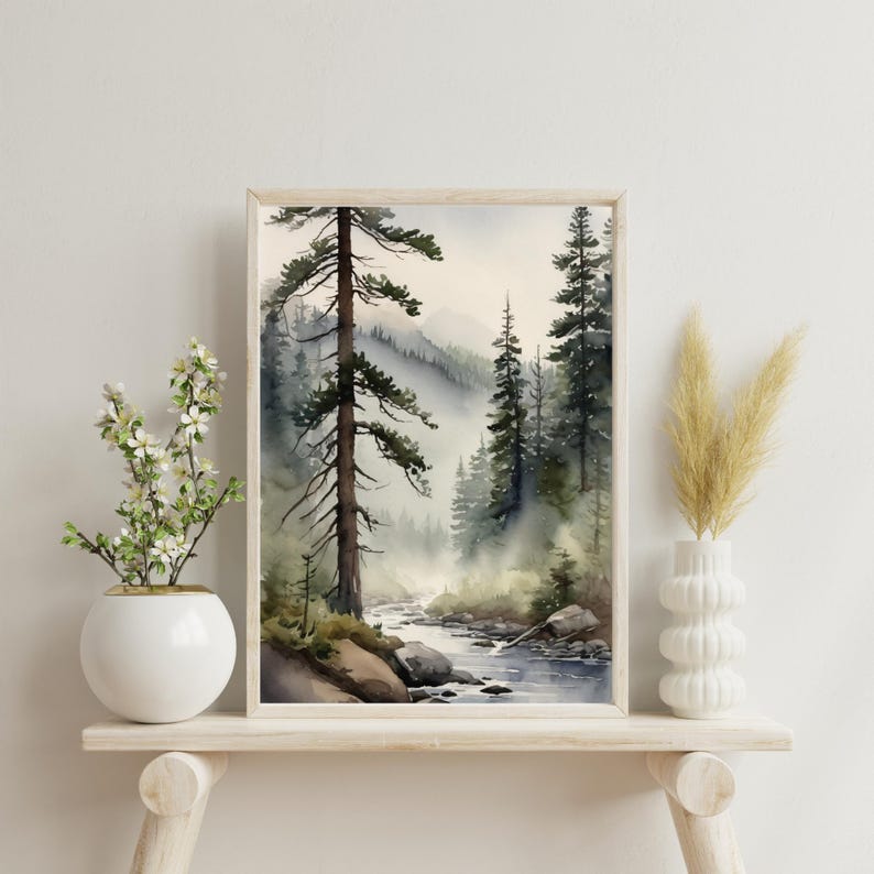 May include: A watercolor painting of a misty forest scene with a river flowing through it. The painting features tall, dark green trees and a light blue sky. The river is a light blue color and has small rocks in it.