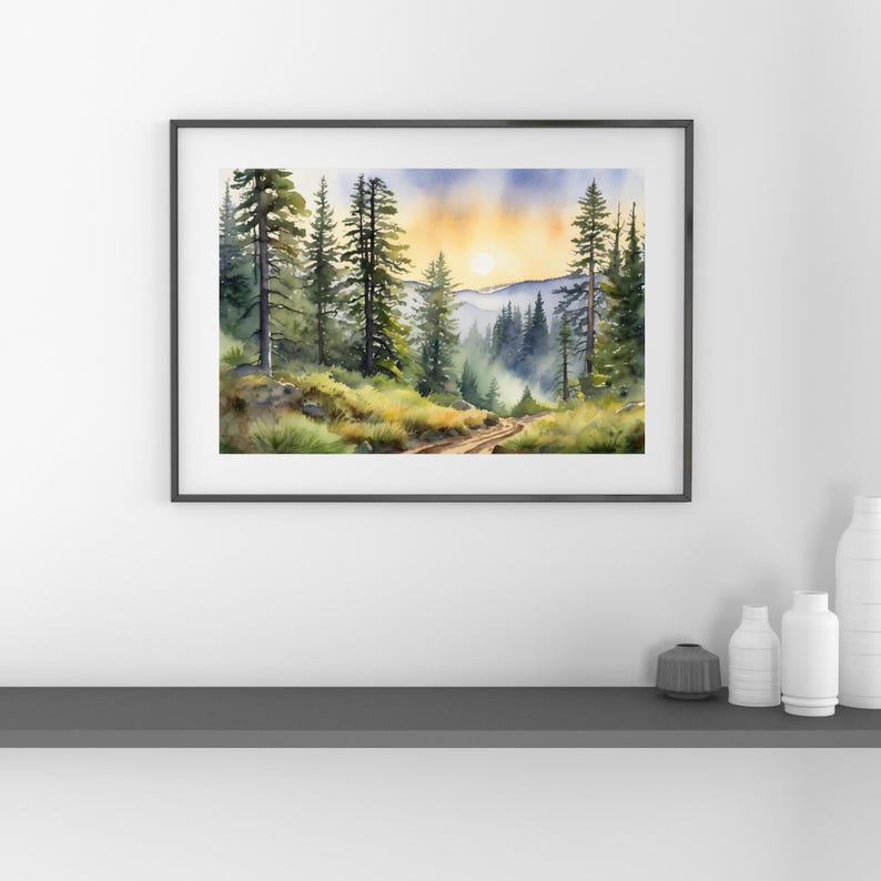 Op de afbeelding: Waterverf schilderij van een bospaadje dat naar een bergketen leidt met een zon die door de bomen schijnt. Het schilderij is ingelijst in een zwart frame.