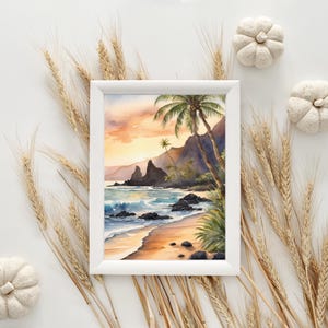May include: A framed watercolour painting of a tropical beach scene. The artwork depicts a sandy beach, ocean waves, palm trees, and mountains under a sunset sky. The frame is white, and the overall aesthetic is serene and natural.