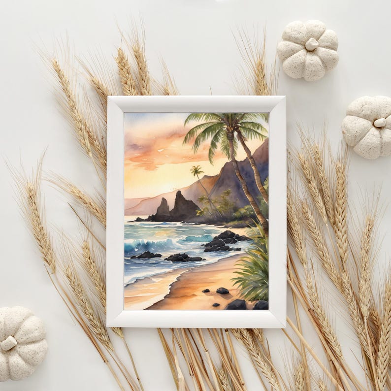 May include: A framed watercolour painting of a tropical beach scene. The artwork depicts a sandy beach, ocean waves, palm trees, and mountains under a sunset sky. The frame is white, and the overall aesthetic is serene and natural.